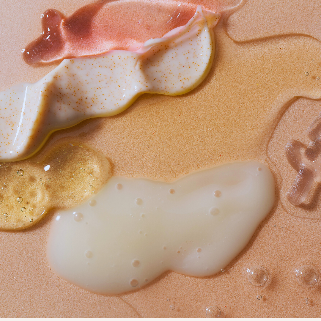 Close-up of textured beige surface with white and pinkish-brown liquid patches